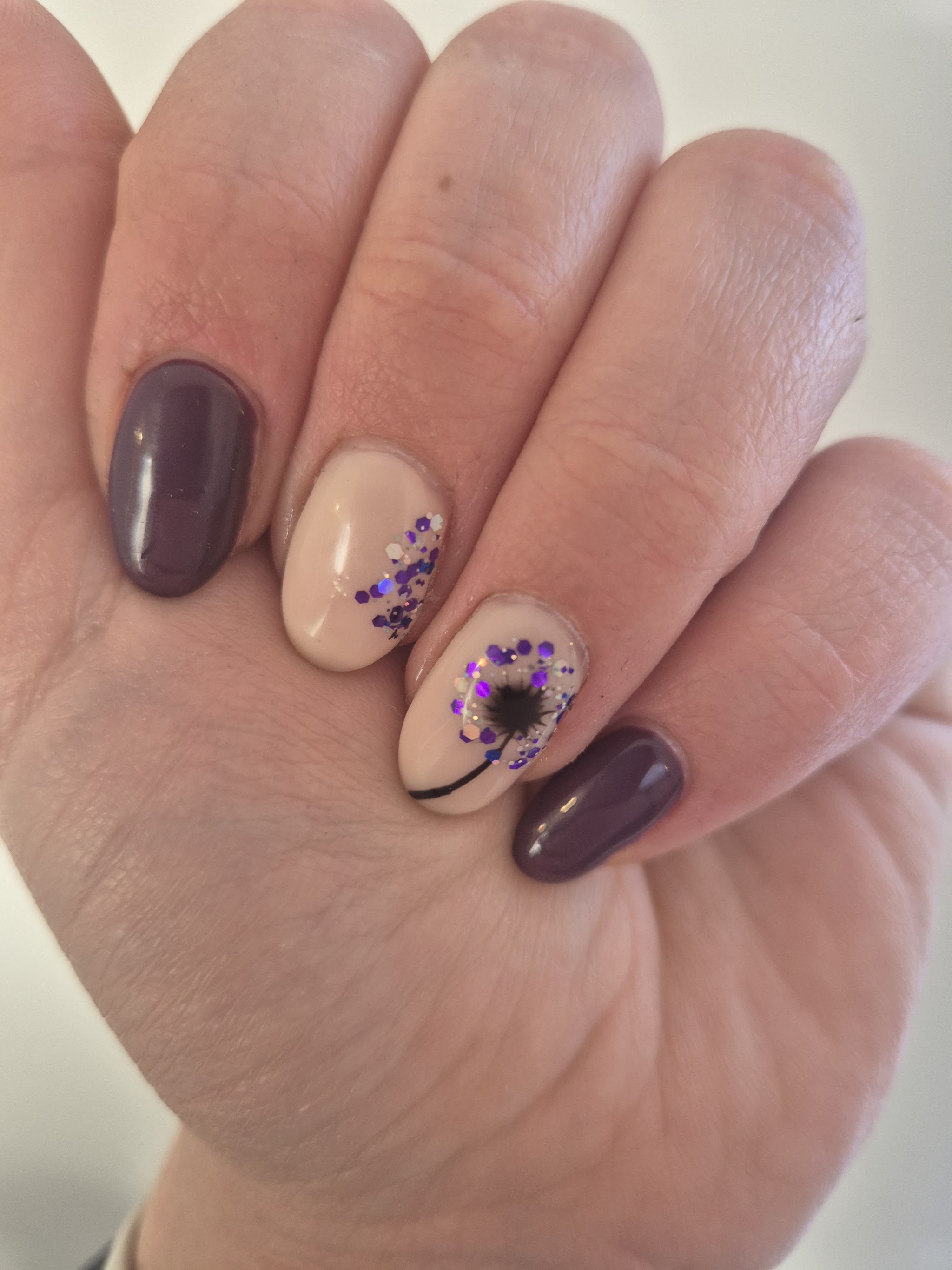 Plum and nude nails with a purple dandelion design